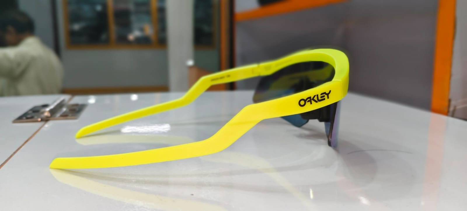 Dukaan mein Oakley sports sunglasses, neon peela frame